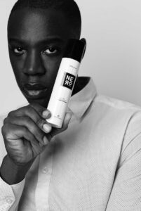 Homme tenant un flacon de gel nettoyant Nero près de son visage