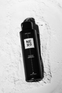 Flacon de shampoing Nero posé sur une surface claire